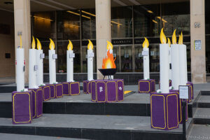 Large structural candles surrounding a fire in front of the Galbraith building